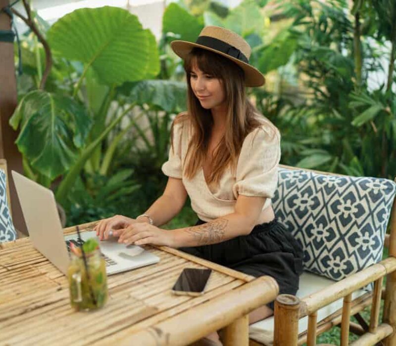 pretty-woman-straw-hat-using-lap-top-while-traveling-asia-working-remotely-stylish-tropical-cafe